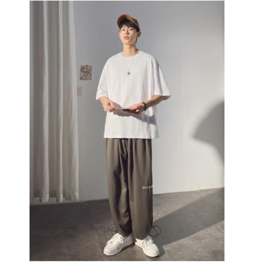 아이보리·블랙 톤 셔츠와 트레이닝팬츠 전신 코디 사진